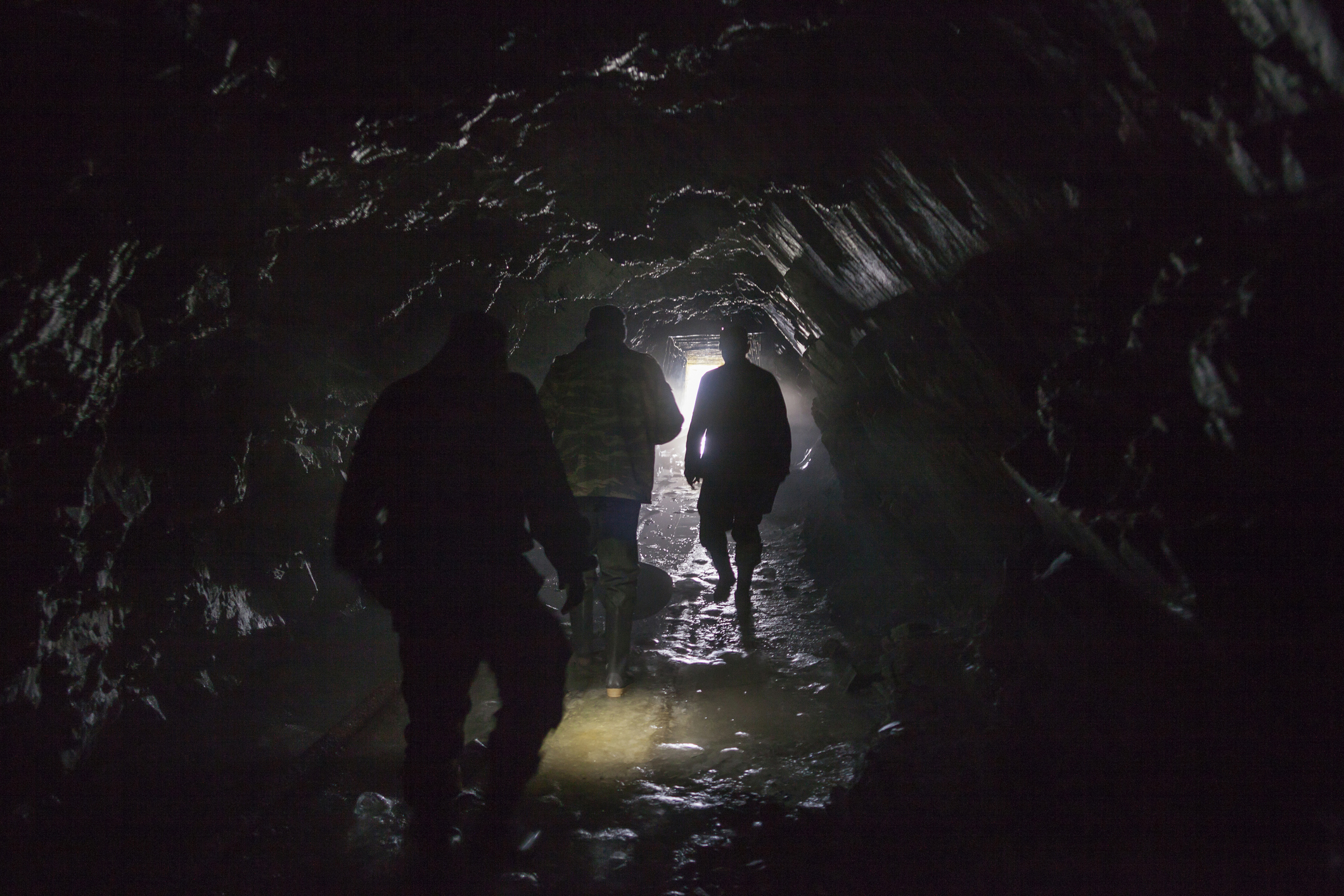 Men walking in dark cave